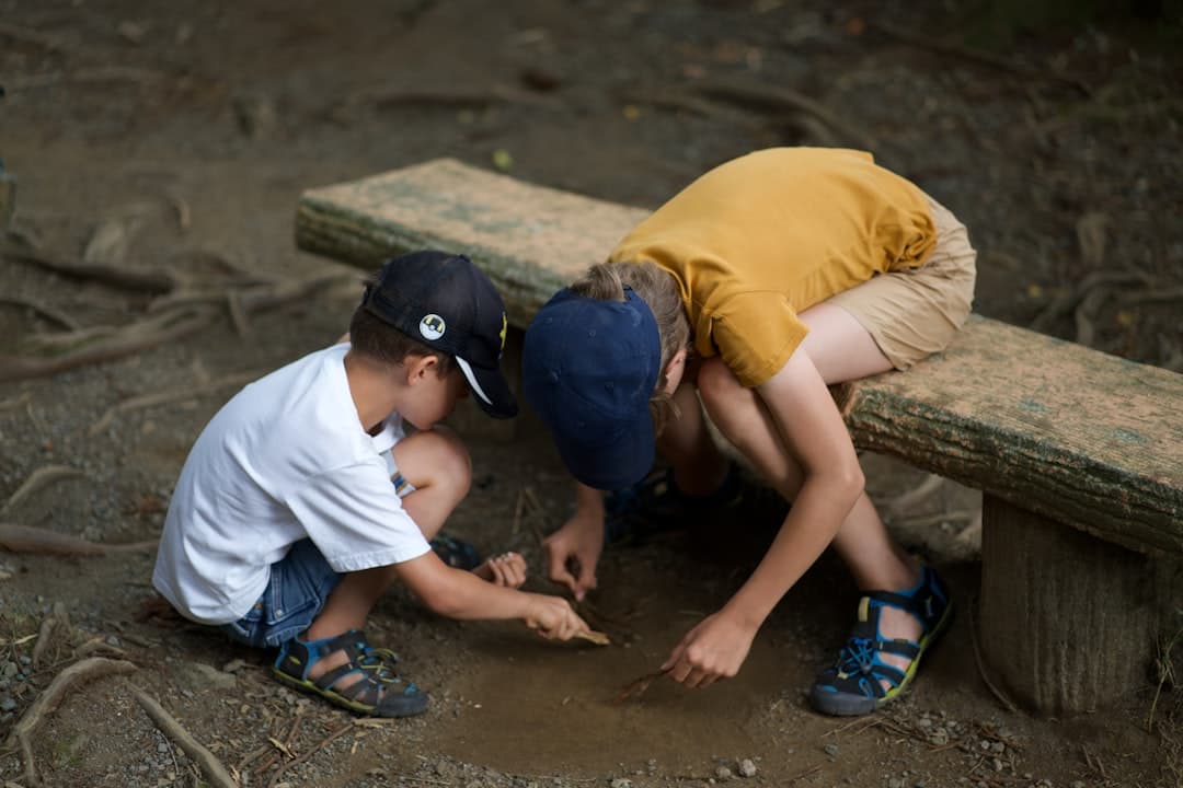 Two children examining something on the forest floor