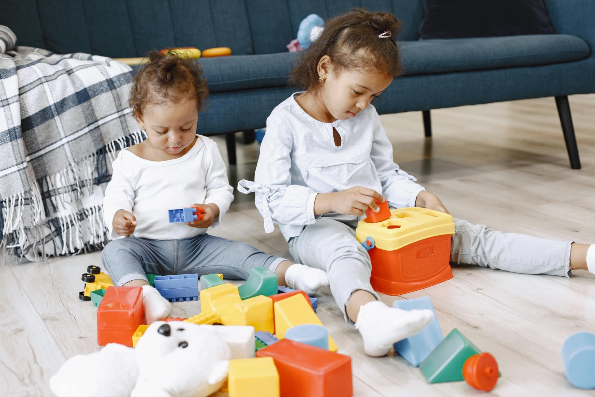 Two children playing on the living room floor